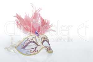 Beautiful carnival mask with pink feathers and a reflection
