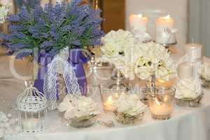 Table decorated with candles, hydrangeas and white roses