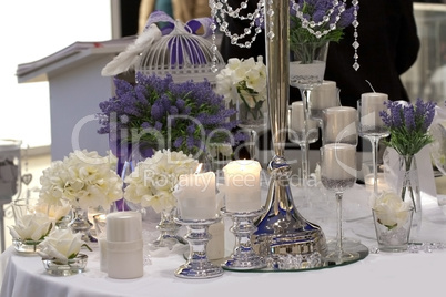 Table decorated with candles, lavender and white roses