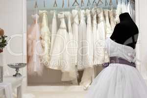 The range of wedding dresses on hangers and on a mannequin in th
