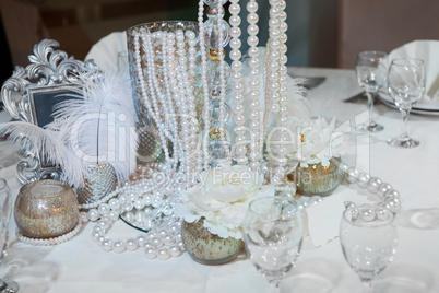Table decorated with feathers, pearls and candles