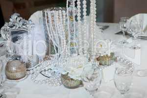 Table decorated with feathers, pearls and candles