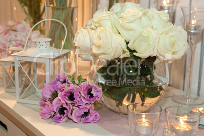 Table decorated with candles and white roses