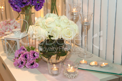 Table decorated with candles and white roses