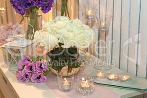 Table decorated with candles and white roses