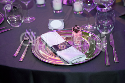Detail of a wedding dinner setting with purple reflection