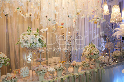 Table decorated with flowers, crystal and cakes