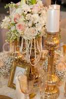 Table decorated with flowers, pearls and candles
