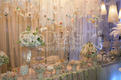 Table decorated with flowers, crystal and cakes