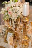 Table decorated with flowers, pearls and candles