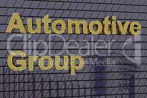 House facade with golden lettering "Automotive Group"