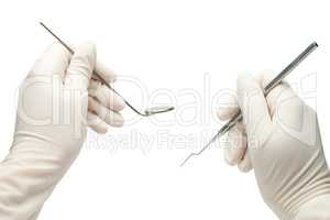 hands of dentist holding his tools during patient examination is