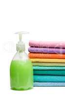 colorful towels and liquid soap isolated over white background