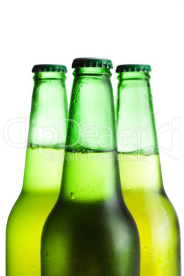 three green beer bottles isolated over white