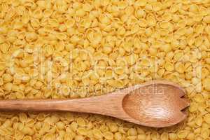 wooden spoon on uncooked macaroni background