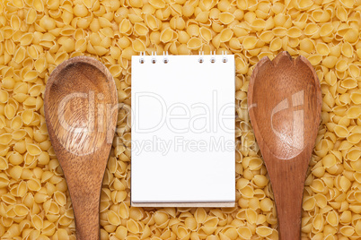 wooden spoons on dry uncooked macaroni background
