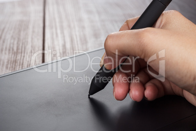 hand of the designer with pen on tablet