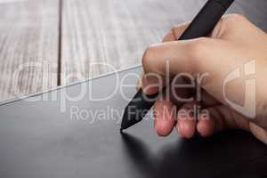 hand of the designer with pen on tablet