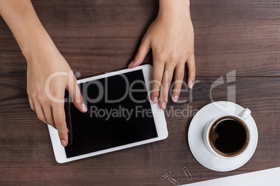 women hands with tablet computer and coffee on table