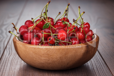 wooden bowl full of cherries on table