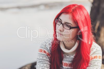 red-haired woman sitting near the river