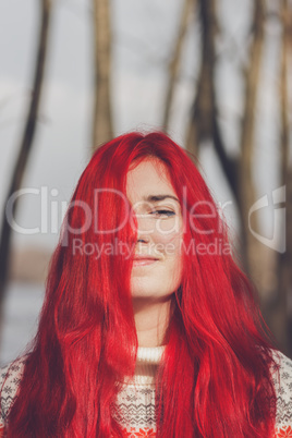 red-haired woman standing near the river