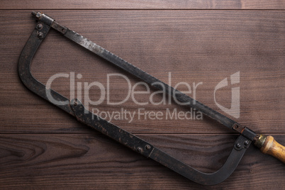 old hacksaw rusty on wooden background
