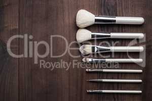 white make-up brushes on wooden table