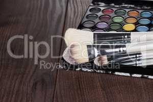 white make-up brushes on wooden background