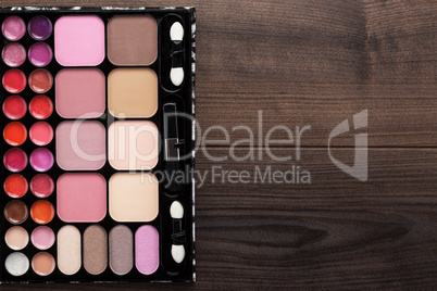 make-up palette on brown wooden background