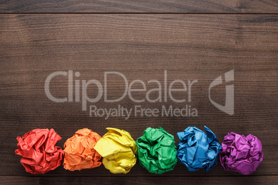 crumpled colorful paper on wooden background