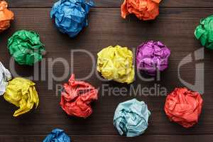 crumpled colorful paper on wooden background