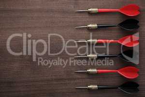 red and black darts on wooden background
