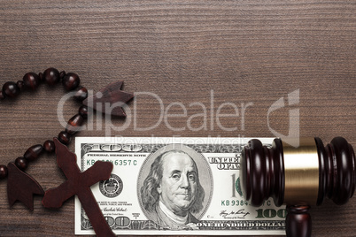 wooden cross gavel and money on brown table background
