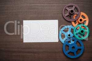 colorful gears on the brown wooden background