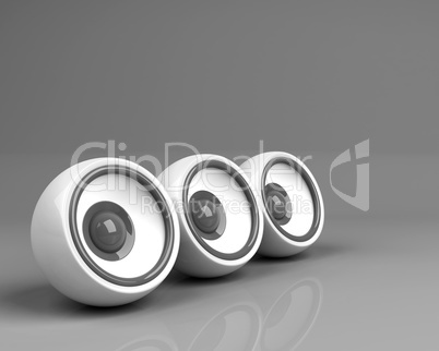 three white speakers over grey background