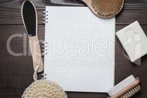 bath accessories and blank notepad over wooden background