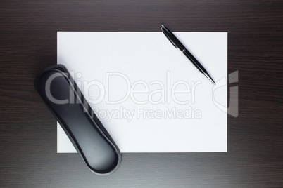 blank sheet of paper on the table with a pen and a telephone