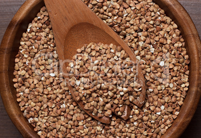 brown wooden bowl full of buckwheat close-up