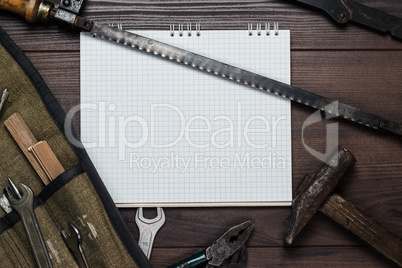 construction tools and blank notepad on the wooden background