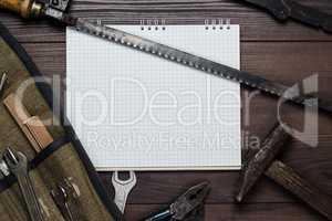 construction tools and blank notepad on the wooden background