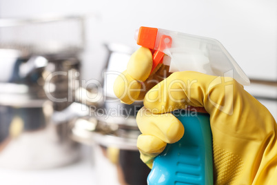 hand in protective glove holding spray. cleaning a kitchen conce