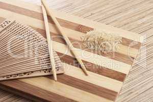 raw rice on the breadboard with chopsticks