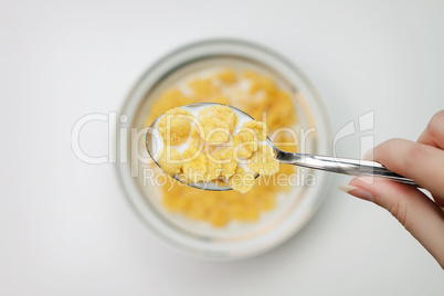 spoon full of cornflakes in hand close-up breakfast concept