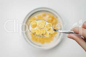 spoon full of cornflakes in hand close-up breakfast concept