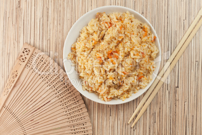 cooked rice with chopsticks and fan