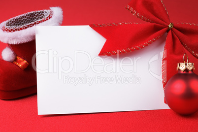 greeting card and christmas decoration over red background