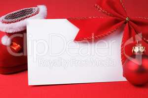 greeting card and christmas decoration over red background