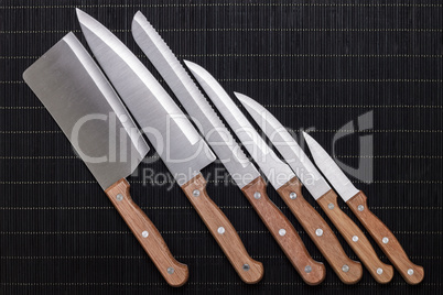 set of kitchen knifes on black mat