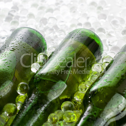 three green beer bottles in the ice